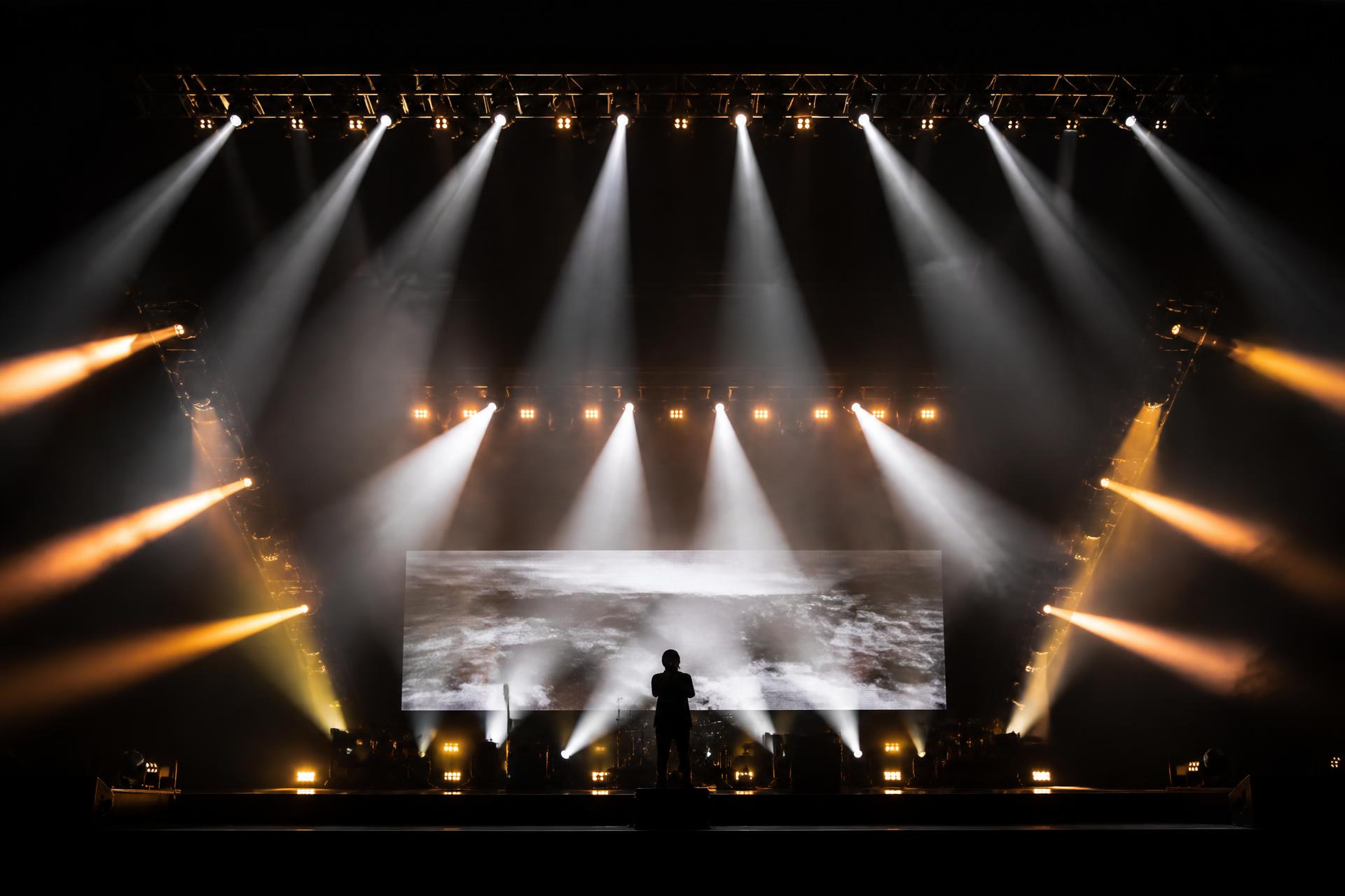 Professional stage lighting with dramatic beams over a performance